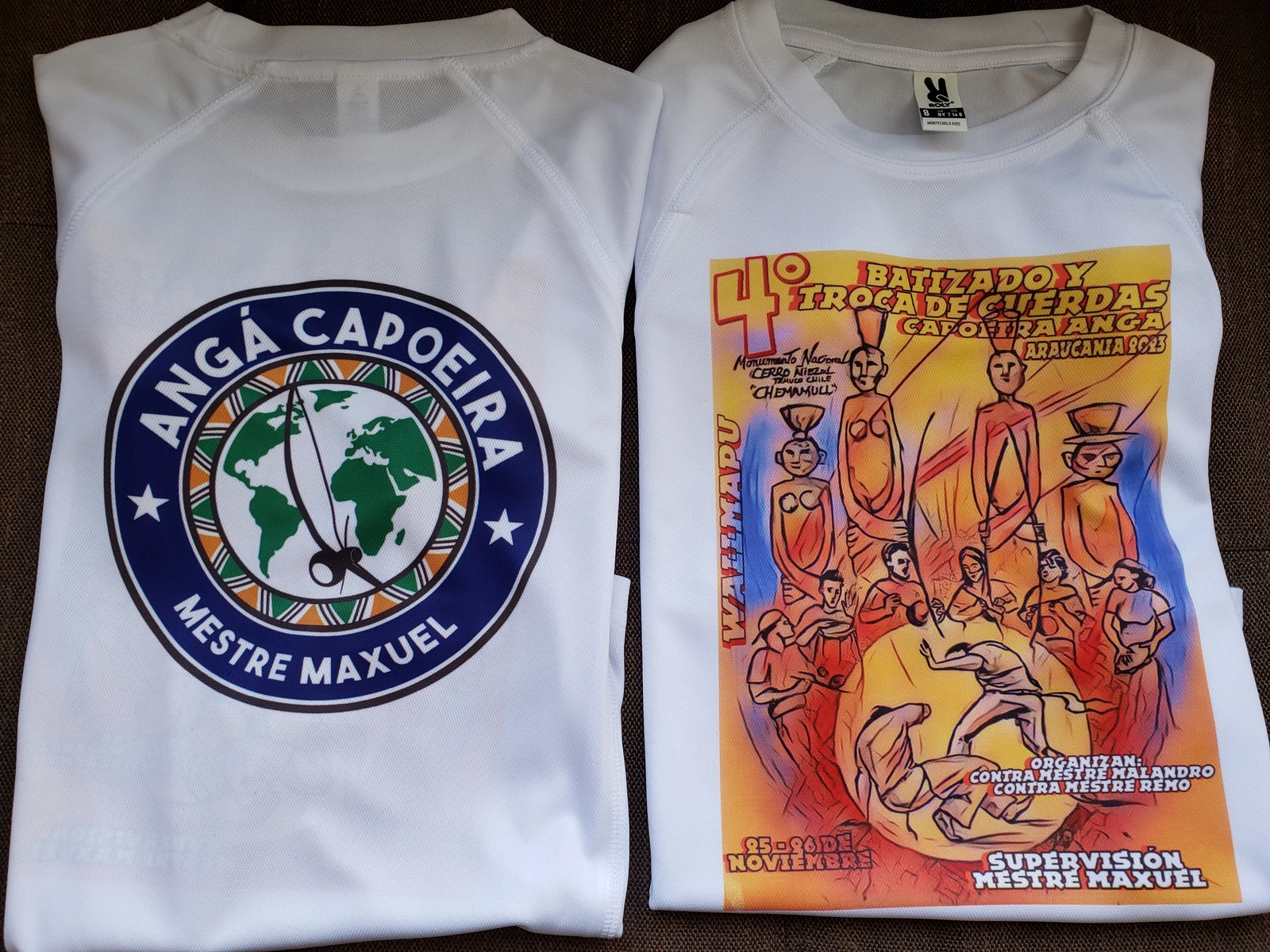 Poleras blancas con el emblema de ANGÁ y un diseño para una actividad de capoeira